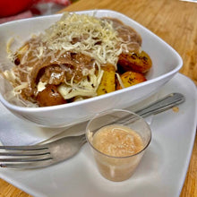 Irish Red Potato Poutine in a white bowl on a white plate next to a fork and horsraddish sauce